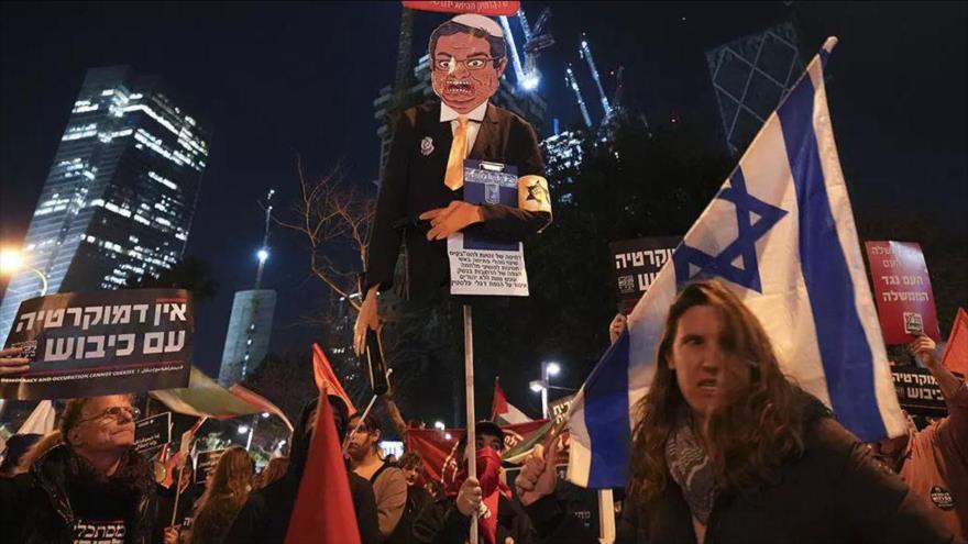 Manifestantes alzan una caricatura del ministro de seguridad israelí, Itamar Ben-Gvir, durante una protesta en Tel Aviv, 18 de febrero de 2023.