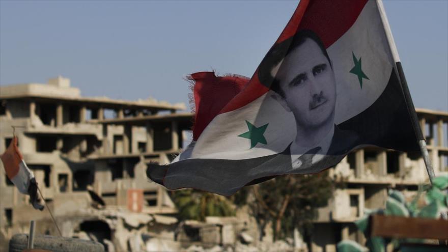 Una bandera de Siria con la imagen del presidente del país, Bashar al-Asad. (Foto: AP)