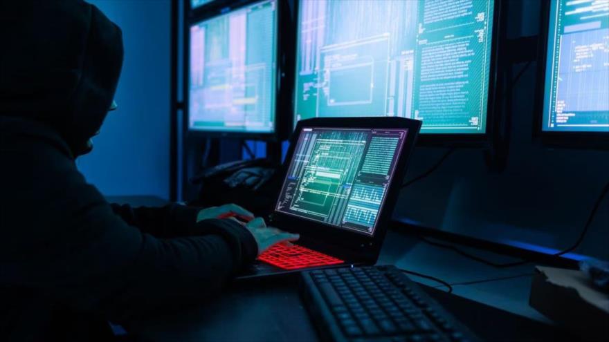 Un hacker con una máscara negra en una sala de servidores. (Foto: Getty Images)