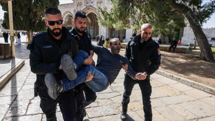 Uniformados israelíes detienen a un hombre palestino tras un brutal asalto israelí a la Mezquita Al-Aqsa, 5 de abril de 2023. (Foto: AFP)