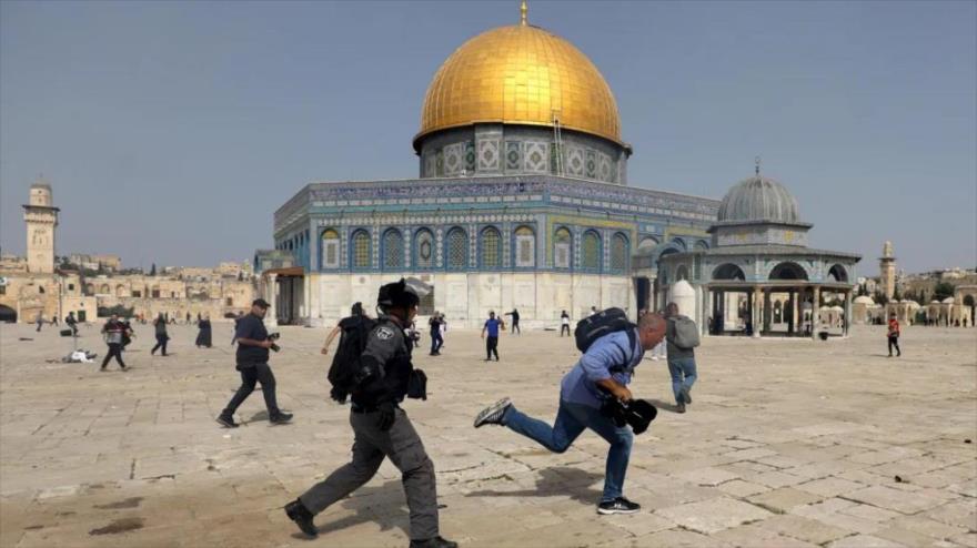 La policía israelí persigue a un camarógrafo que cubre la redada contra los palestinos en el complejo de Mezquita Al-Aqsa. (Foto: Reuters)