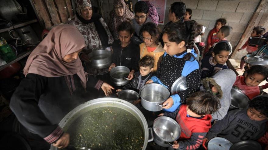 Una cocinera voluntaria palestina distribuye alimentos para ayudar a familias necesitadas en un barrio en Gaza en enero de 2021. (Foto: AFP)