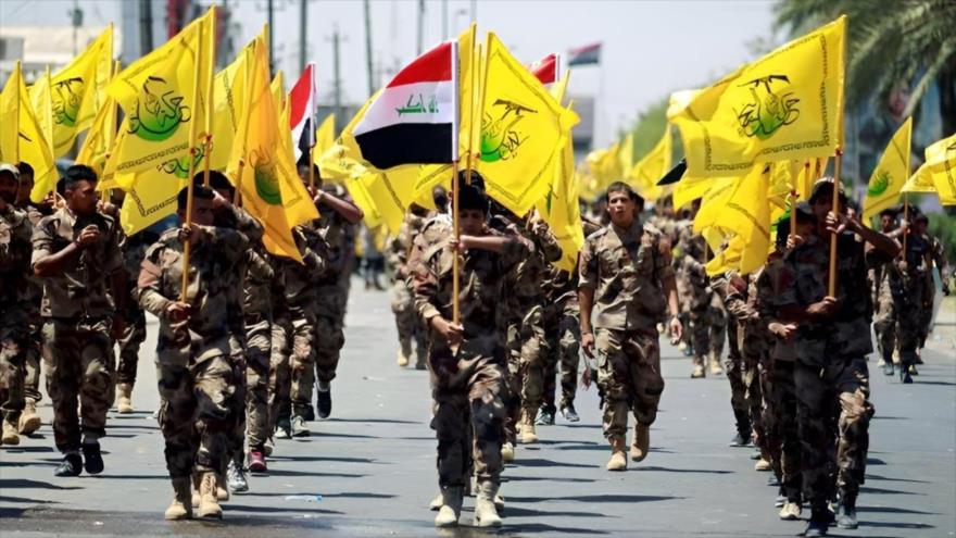 Combatientes del movimiento popular iraquí Hezbolá Al-Nuyaba participan en un desfile militar.