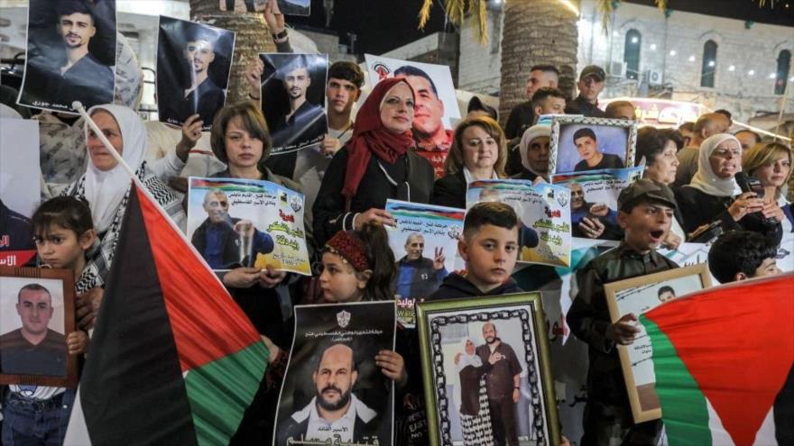 Conmemoran Día del Prisionero llevando fotos de los presos palestinos en cárceles israelíes en Cisjordania ocupada, 17 de abril de 2023. (Foto: AFP)