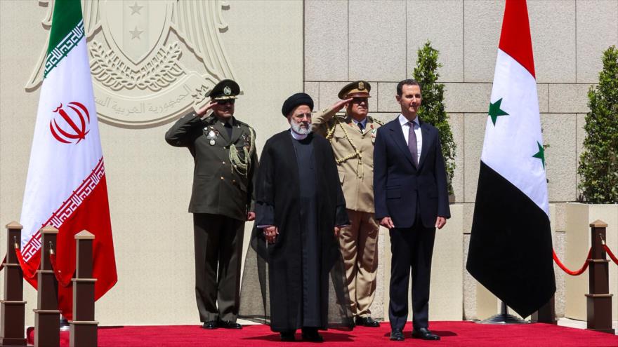 El presidente de Irán, Ebrahim Raisi (izda.), recibido por su par sirio, Bashar al-Asad, en el Palacio del Pueblo en Damasco, 3 de mayo de 2023.