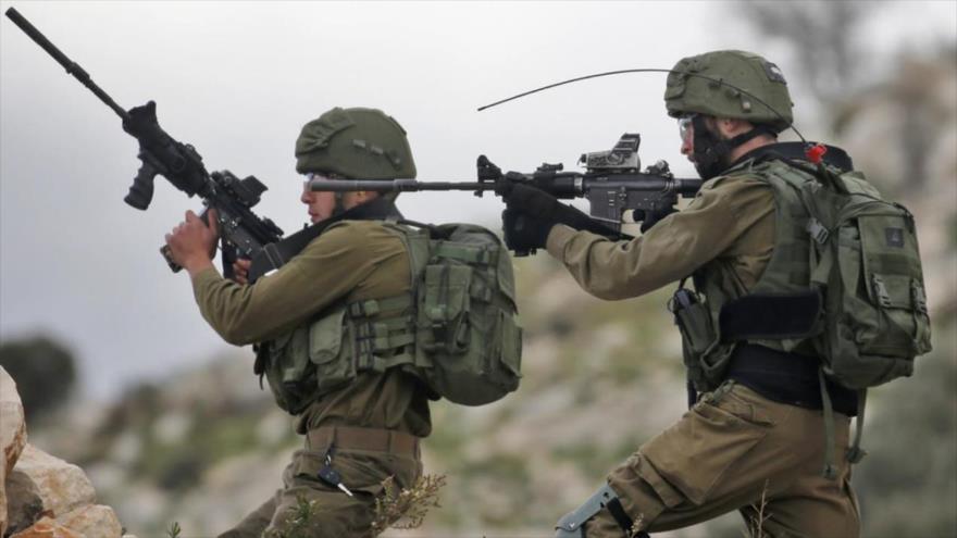 Soldados israelíes apuntan sus rifles a los manifestantes palestinos en la aldea de Kfar Qaddum, cerca de Nablus, en la Cisjordania ocupada. (Foto: AFP)