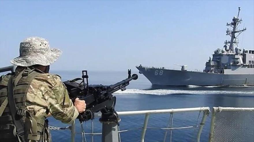 Un soldado de la Armada del CGRI de Irán vigila el movimiento de un buque estadounidense en el Golfo Pérsico.