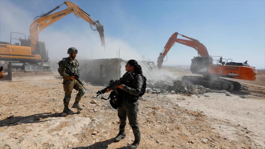 Fuerzas israelíes cerca de excavadores que demuelen una casa palestina en una zona en la Cisjordania ocupada, 4 de julio de 2022. (Foto: Reuters)