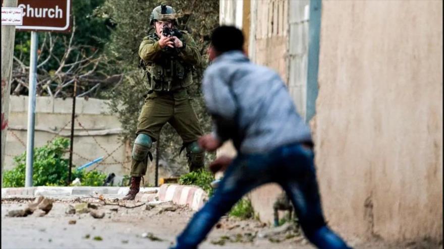 Un soldado israelí apunta su arma contra un palestino en un enfrentamiento en el norte de Cisjordania. (Foto: AFP)