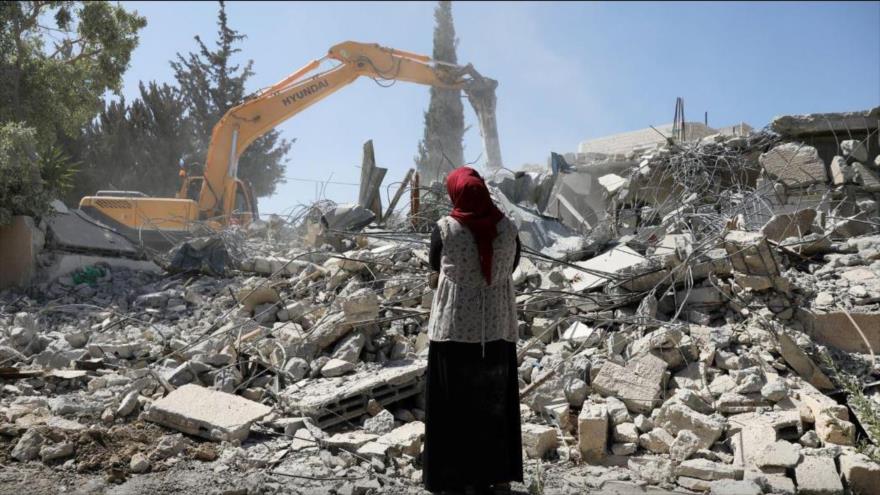 Una mujer palestina mira a las ruinas de su casa destruida por las fuerzas israelíes en la ocupada Al-Quds.