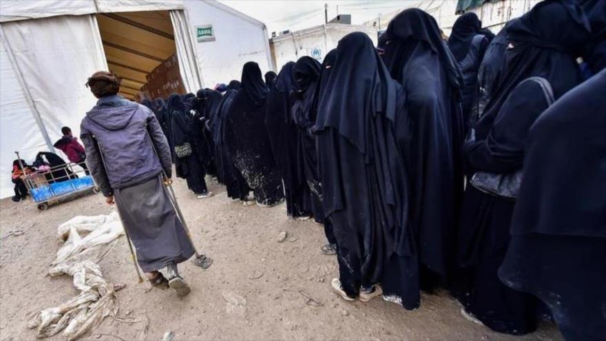 Las mujeres de terroristas de Deash que viven en el campo Al-Hol de Siria hacen fila para recibir bienes, marzo de 2019. (Foto: AFP)