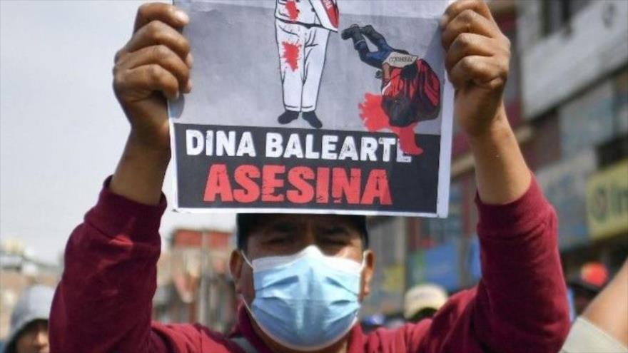 Un manifestante sostiene un cartel pidiendo la renuncia de la presidenta Dina Boluarte. 