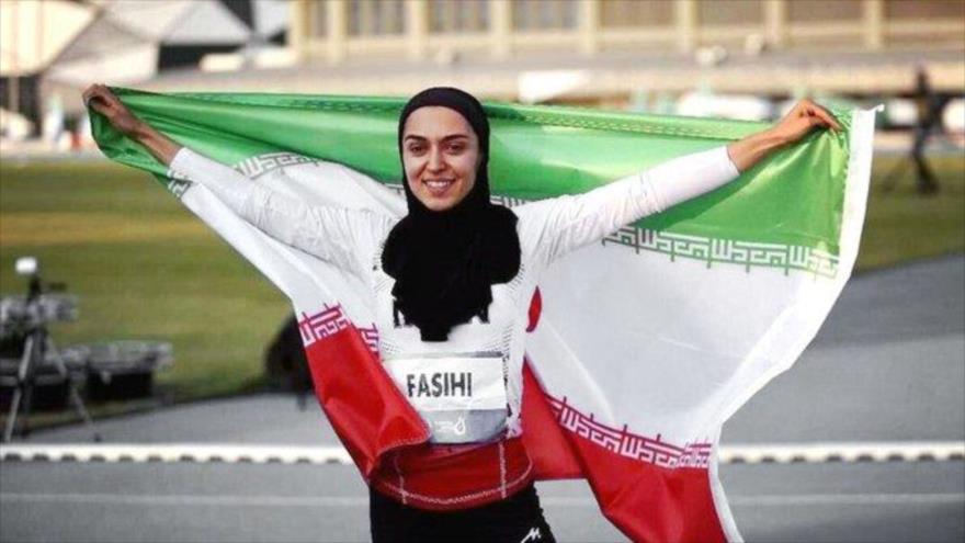 La atleta iraní, Farzaneh Fasihi con la bandera de Irán.