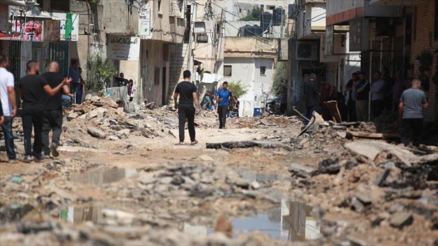 Los palestinos caminan por las calles destruidas después de ataques aéreos y una redada israelíes en la ciudad de Yenín, 3 de julio de 2023.