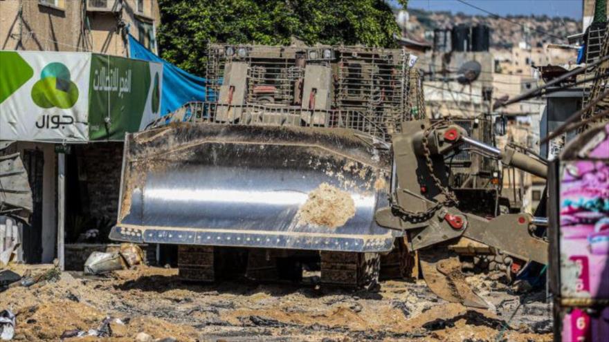  
Una excavadora militar israelí destruye el centro del campamento de refugiados de Yenín durante una redada, 3 de julio de 2023. 
