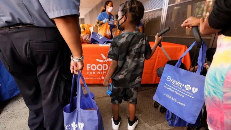 Un niño pequeño observa cómo la gente recoge alimentos en el marco de un programa de ayuda en Nueva York, 2 de septiembre de 2021. (Foto: Getty Images)