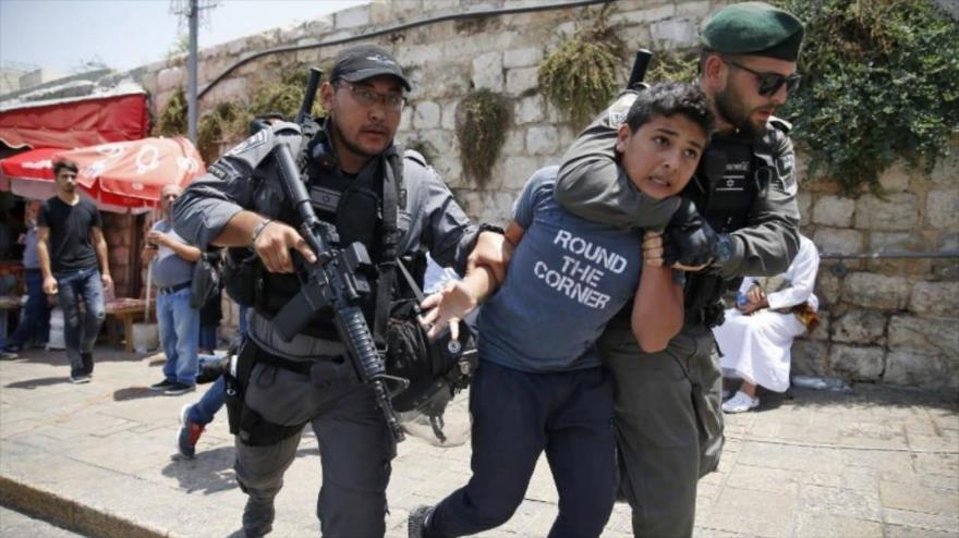 Militares israelíes detienen a un niño palestino durante una manifestación frente a la entrada principal al recinto de la Mezquita Al-Aqsa, 17 de julio de 2017. (Foto: AFP)