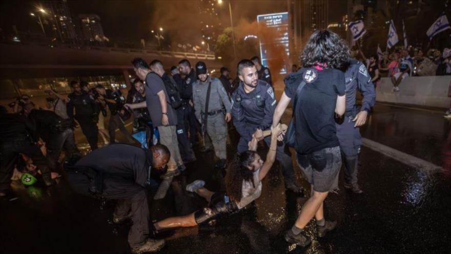 Policías israelíes arrestan a una manifestante en protestas contra Benjamín Netanyahu, Tel Aviv, 8 de julio de 2023.