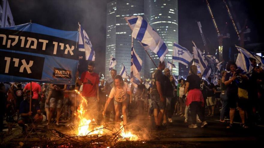 Los manifestantes levantan encienden un fuego en la autopista Ayalon en Tel Aviv, 5 de julio de 2023. (Foto: AFP)