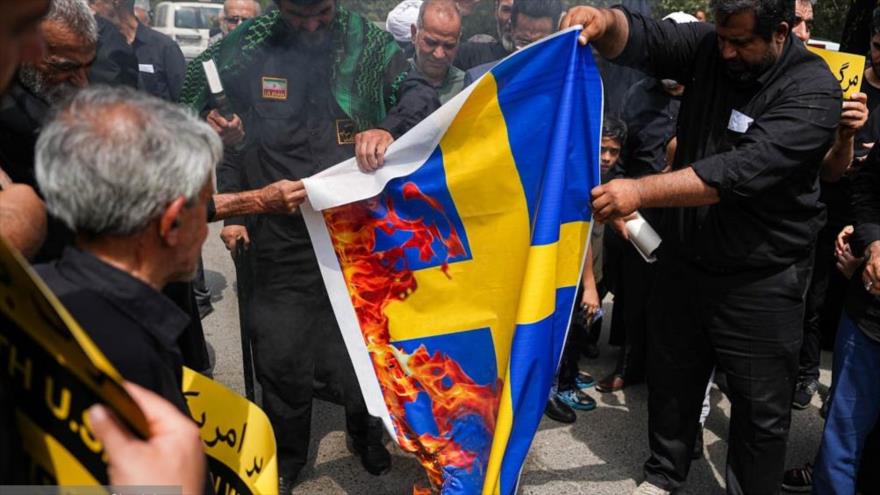 Los manifestantes iraníes prenden fuego a la bandera sueca en protesta por la profanación del Sagrado Corán en Suecia, Teherán, 21 de julio de 2023. (Foto: FARS)