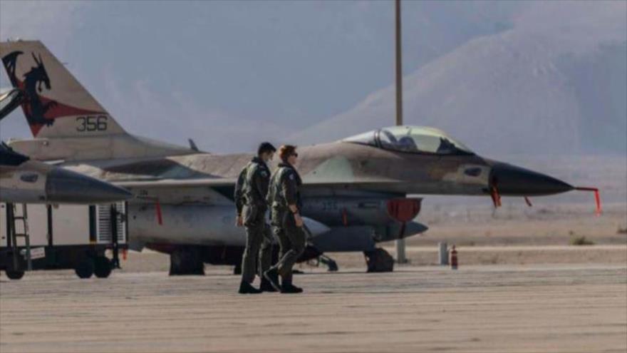 Pilotos de la fuerza aérea israelí caminando cerca de un F-16