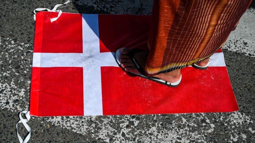 Un manifestante pisa una bandera de Dinamarca durante una protesta en apoyo al Corán en Indonesia.