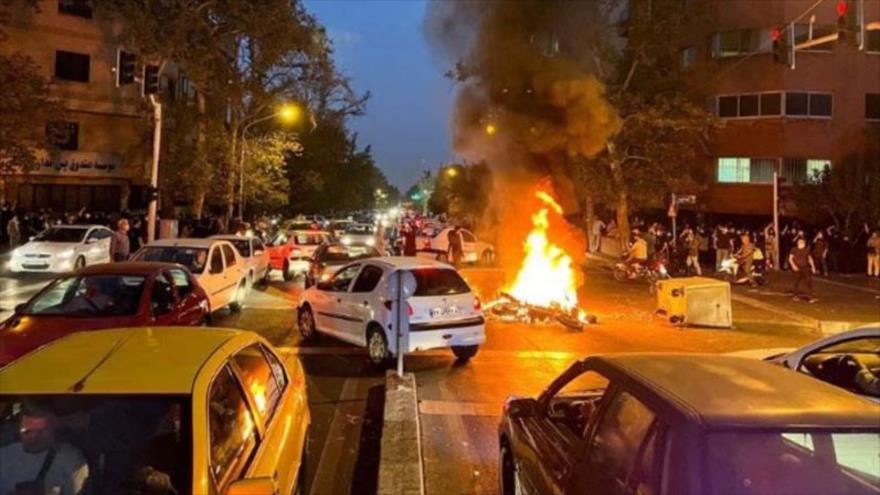 Alborotadores prenden fuego a una motocicleta durante una protesta por la muerte de Mahsa Amini en Teherán, 19 de septiembre de 2022.