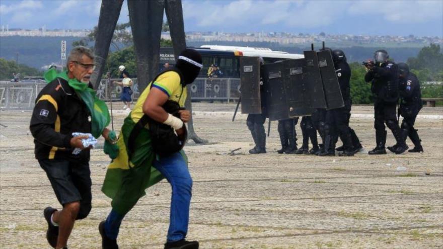 Las fuerzas de seguridad confrontan a los partidarios del expresidente brasileño Jair Bolsonaro cuando invaden el Palacio Presidencial de Planalto en Brasilia el 8 de enero de 2023. (Foto: AFP)