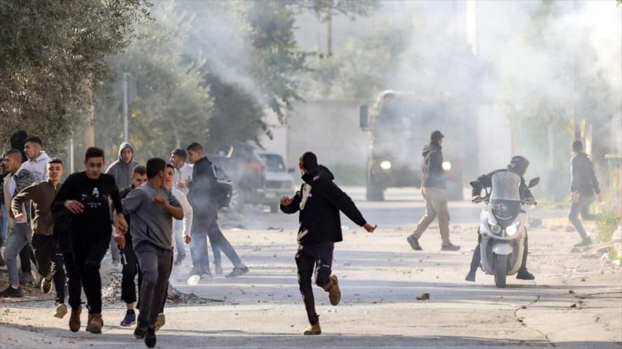 Los palestinos corren en busca de refugio durante los enfrentamientos con las fuerzas israelíes en la ciudad ocupada de Yenín, en Cisjordania. (Foto: AFP)