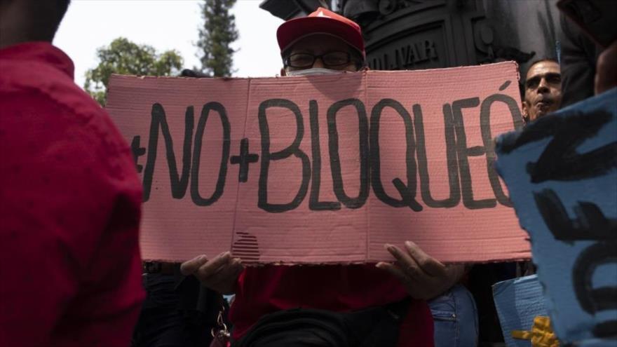 Un manifestante sostiene un cartel en rechazo a las sanciones estadounidenses durante un evento en la Plaza Bolívar en Caracas, 9 de marzo de 2023.