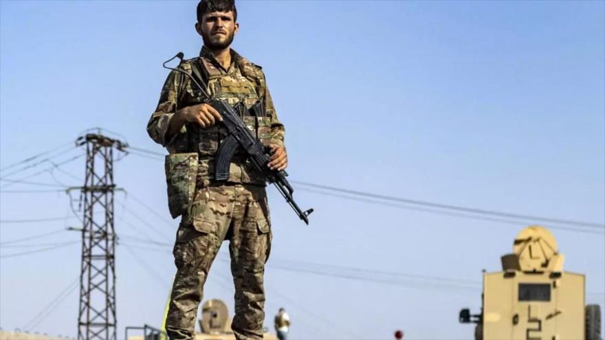 Un miembro de las Fuerzas Democráticas Sirias hace guardia en una carretera en la ciudad de Al-Busayrah, en la provincia siria de Deir Ezzor, el 4 de septiembre de 2023 (Foto: AFP)