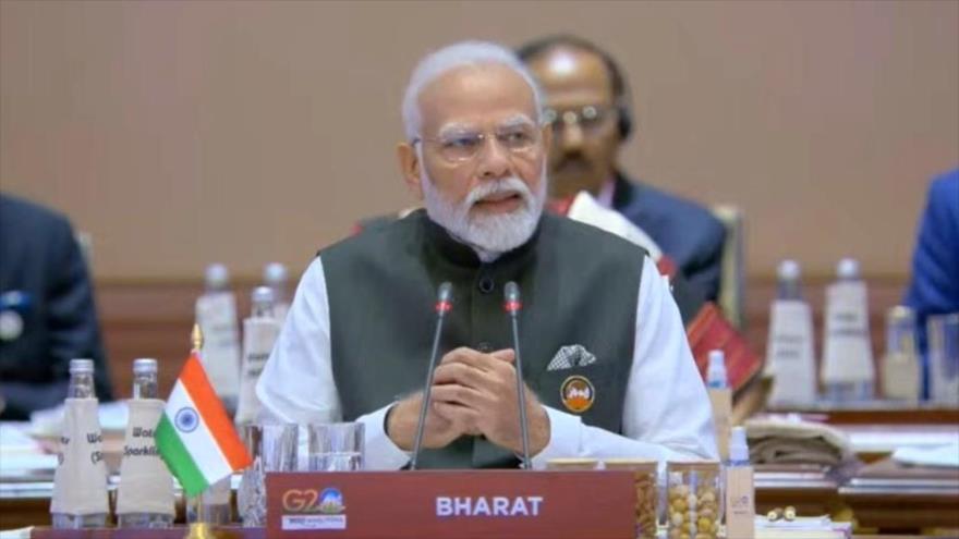 Primer ministro, Narendra Modi, pronuncia un discurso desde una mesa con la inscripción Bharat