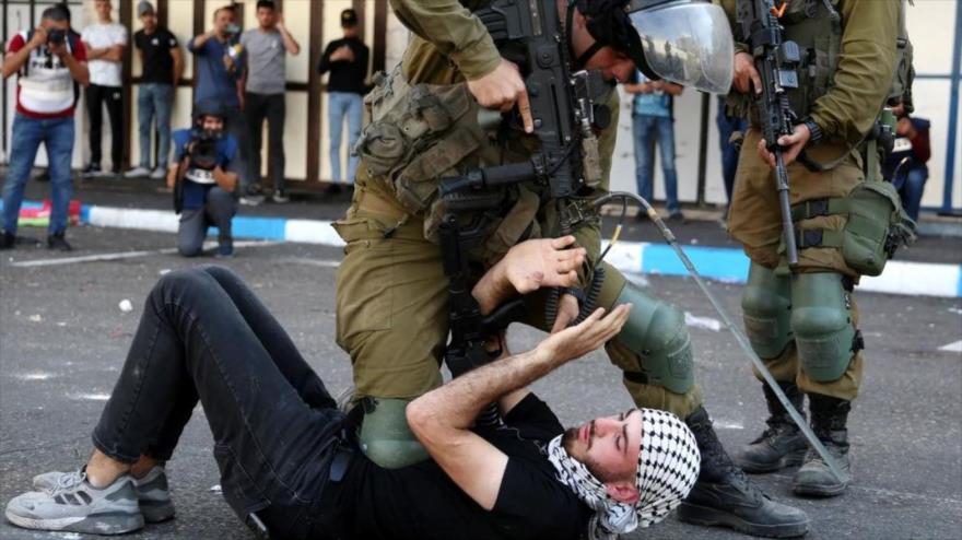 Un soldado sionista ataca a un palestino durante una protesta en ciudad de Hebrón, Cisjordania, en 2018