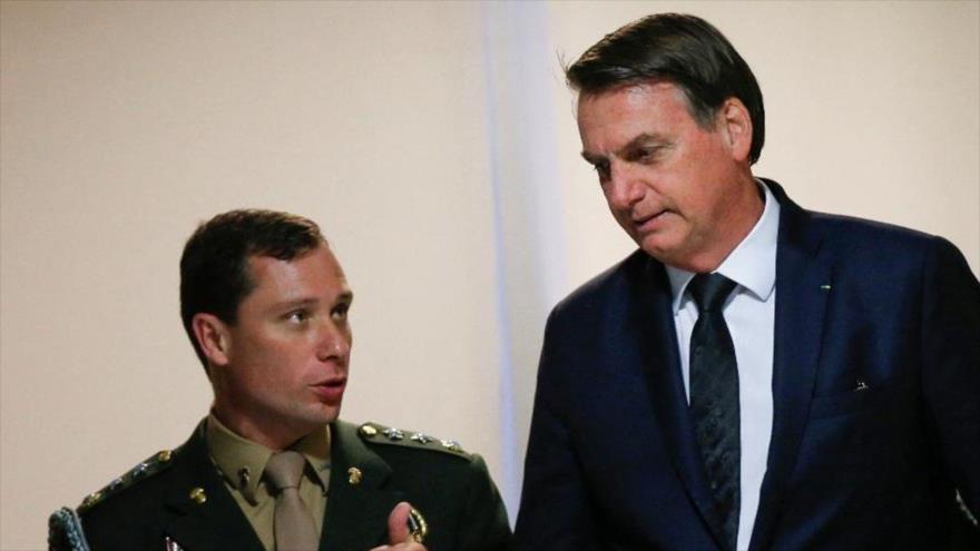 El expresidente de Brasil Jair Bolsonaro habla con su exasesor principal, Mauro Cid, en Brasilia.
