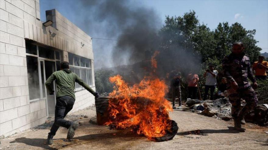 Un palestino corre cerca de un objeto en llamas tras un ataque de colonos israelíes en la Cisjordania ocupada, 21 de junio de 2023. (Foto: Reuters)