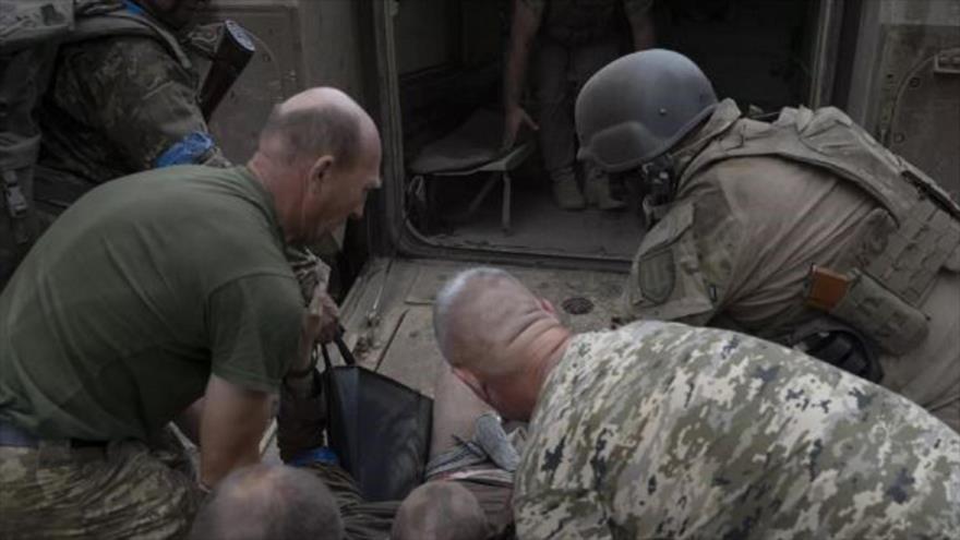 Militares ucranianos llevan a su compañero herido al punto de estabilización en una zona no cerrada cerca de Artemovsk.