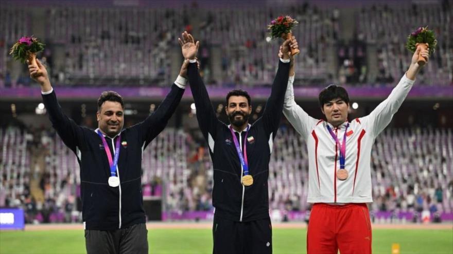 Ehsan Hadadi, ganador de medalla de plata (izda.) y Hosein Rasuli (centro), ganador de medalla de oro en los Juegos Asiáticos de Hangzhou, 2 de octubre de 2023.