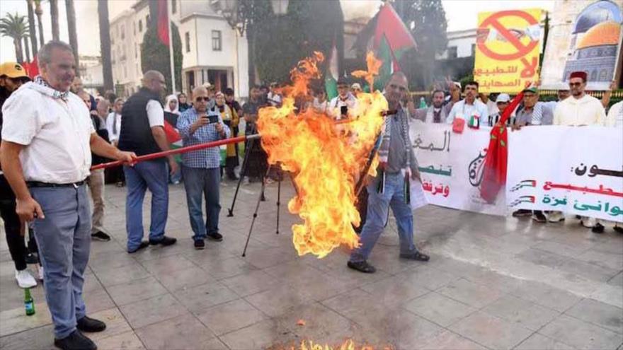 Un manifestante quema una bandera israelí frente al edificio del Parlamento en Rabat durante una manifestación pro-Palestina, 6 de octubre de 2023.
