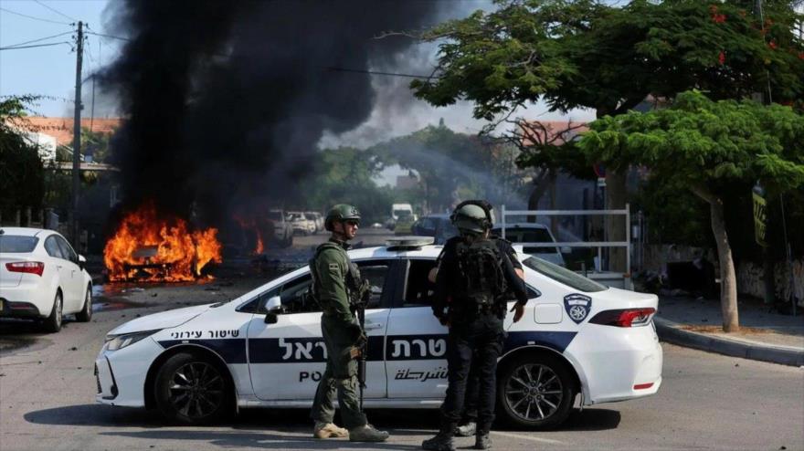Vehículos israelíes arden en llamas tras ataques palestinos con cohetes desde Gaza, 7 de octubre de 2023.