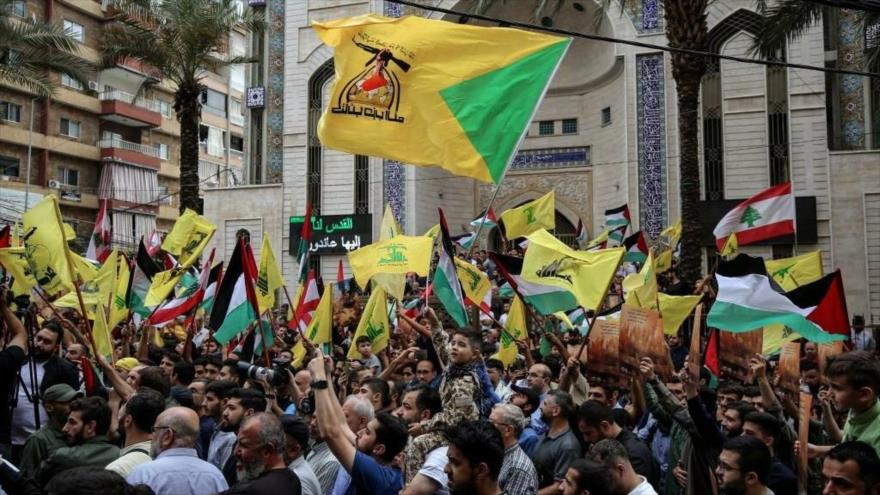 Los simpatizantes de Hezbolá ondean banderas del movimiento libanés y banderas palestinas durante una manifestación en Beirut, 8 de octubre de 2023.