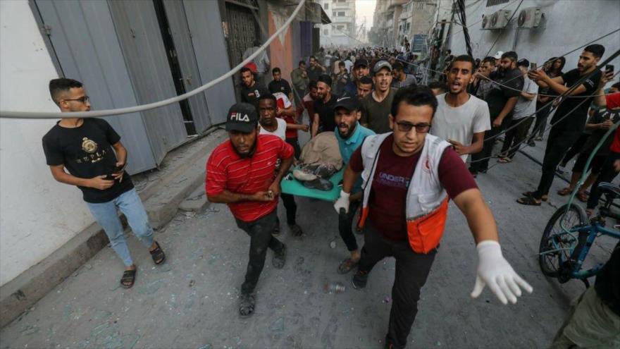 Paramédicos trasladan a un palestino sacado bajo los escombros de un edificio destruido por los ataques israelíes en Gaza, 15 de octubre de 2023.