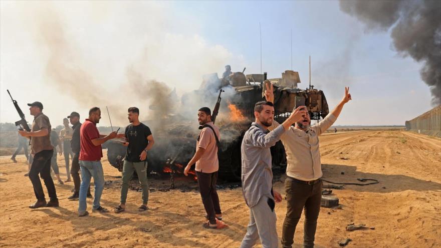 Palestinos toman el control de un tanque israelí después de cruzar la valla fronteriza con Israel desde Jan Yunis en el sur de Gaza, 7 de octubre de 2023.