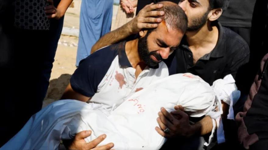 El padre de la niña palestina Alma al-Majayda, de tres años, asesinada en ataques israelíes a Gaza, abraza su cuerpo durante su funeral, octubre de 2023. (Foto: Reuters)