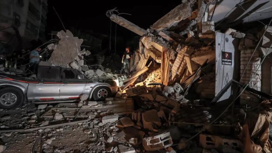 Varias personas inspeccionan la zona de la iglesia ortodoxa griega tras el ataque israelí, en la ciudad de Gaza, 20 de octubre de 2023.