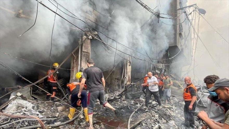 Equipos de rescate acuden a un edificio residencial destruido en los ataques aéreos de Israel en Gaza, octubre de 2023.