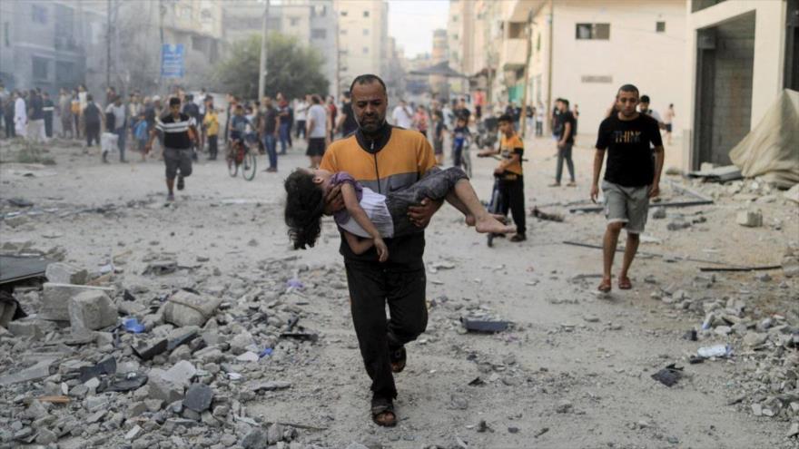 Un hombre palestino sostiene el cuerpo de una niña herida tras los ataques israelíes en el sur de Gaza, noviembre de 2023. (Foto: Reuters)