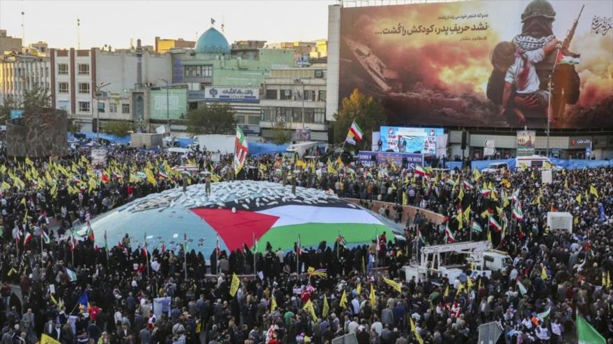 Manifestantes iraníes participan en una marcho en apoyo a los palestinos sosteniendo las banderas de Irán y Palestina, Teherán, 18 de noviembre de 2023. 
