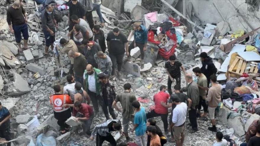 La gente lleva a cabo operaciones de rescate entre los escombros de edificios residenciales tras un ataque israelí en Gaza, 18 de noviembre de 2023.