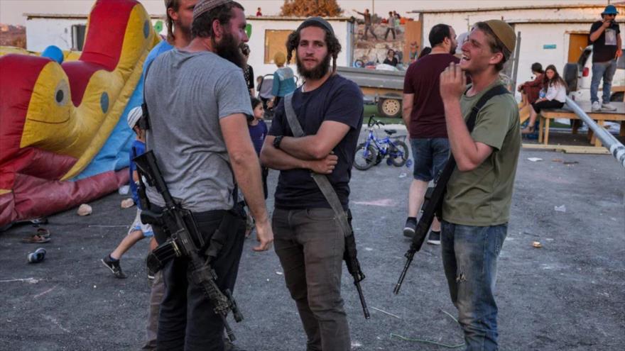 Un grupo de colonos israelíes portando rifles.