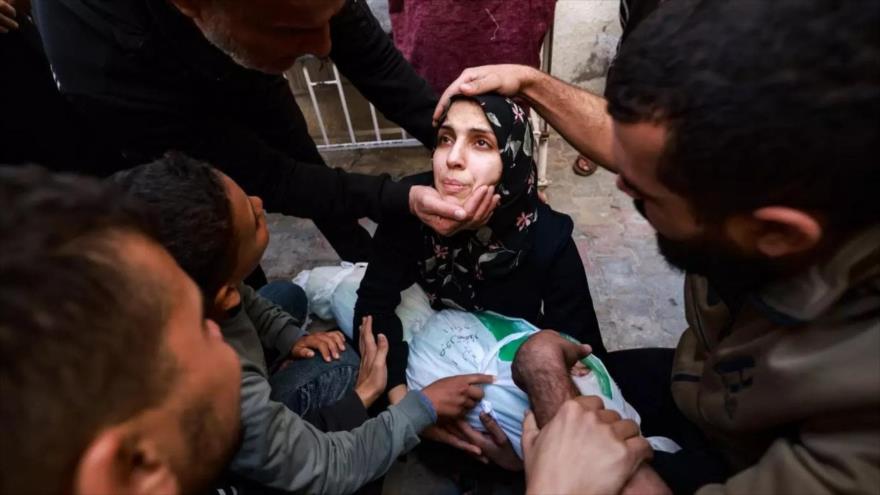Una mujer sostiene el cuerpo de su bebé muerto en un ataque israelí en Rafah, sur de la Franja de Gaza, 1 de diciembre de 2023 (Foto: AFP)